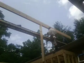Carpenter setting a ridge beam over a new addition frame — Ice Dam Removal by Roofing Brothers in Trout Lake
