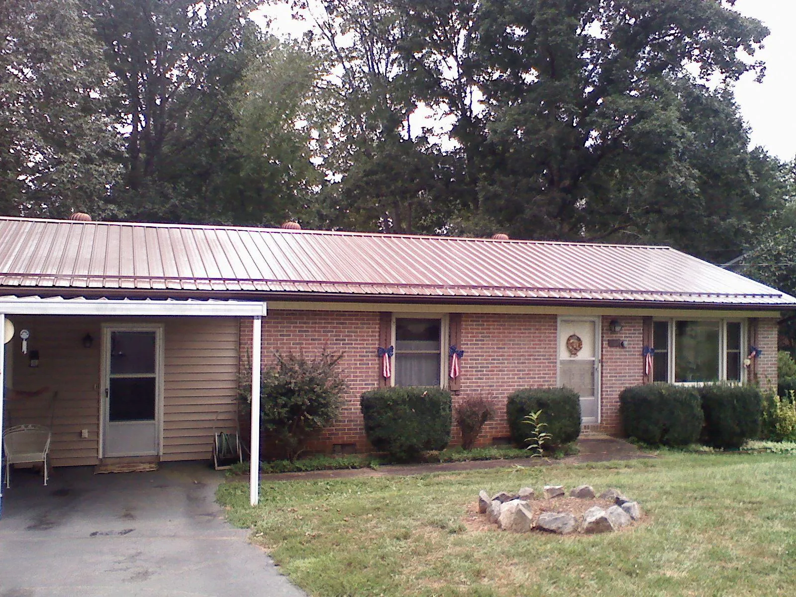 Bronze metal roof and carport on a brick ranch home — Roof Repair work by our crew in Trout Lake